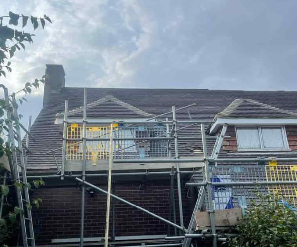 This is a photo of a roof with two dormers that is having some damaged tiles replaced. Works carried out by WDF Roofing St Neots